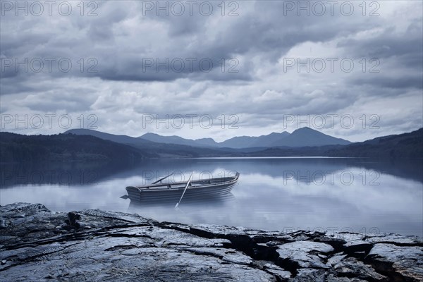 Abandoned rowboat in remote mountain lake