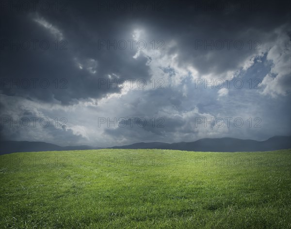 Storm clouds over green field