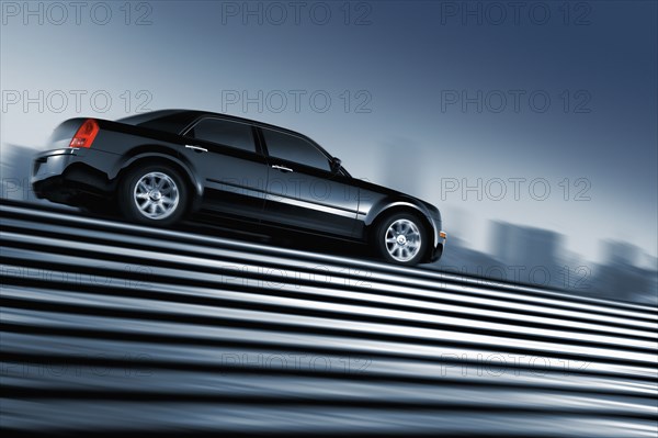 Black car driving at top of urban staircase