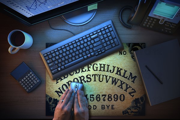 Hands using computer mouse on Ouija board