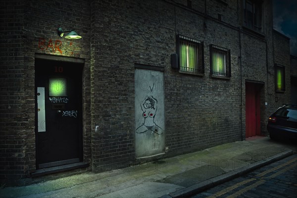 Graffiti on alley doors in city at night