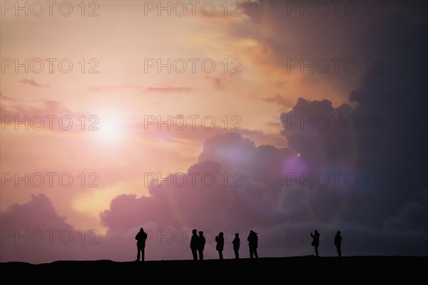 Silhouette of people watching sunset