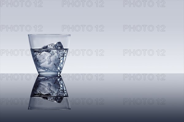 Ice cube in glass of water