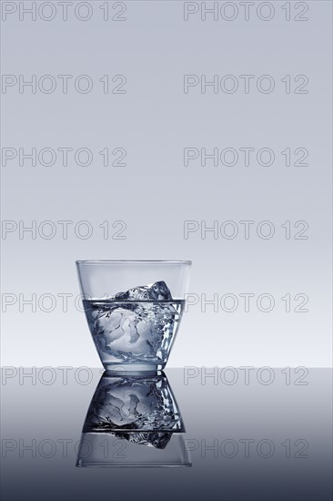 Ice cube in glass of water