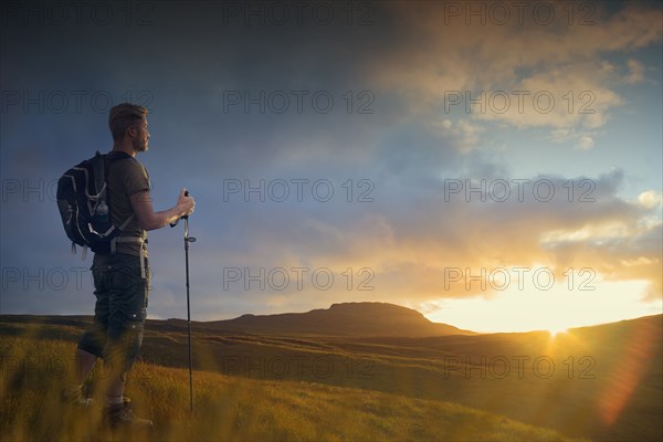 Caucasian hiker admiring landscape at sunset