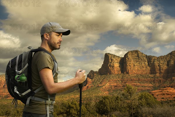 Caucasian hiker holding walking stick in desert landscape