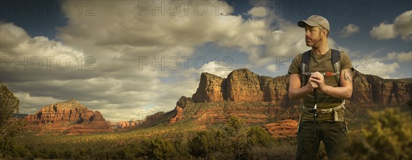 Caucasian hiker holding walking stick in desert landscape