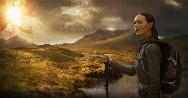 Caucasian woman hiking near mountain river at sunset
