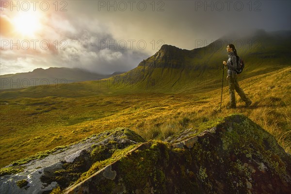 Caucasian woman hiking in green mountain landscape