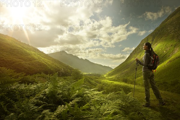 Caucasian woman hiking in green valley