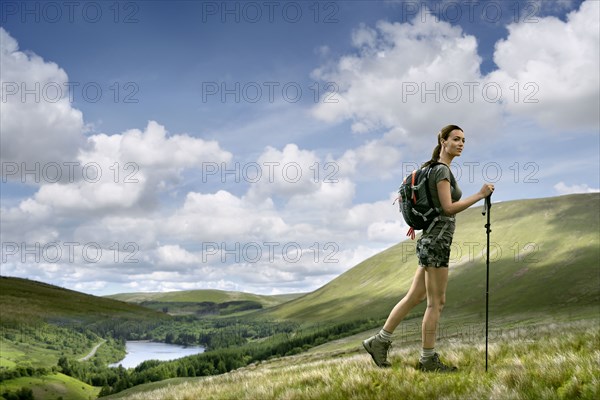 Caucasian woman hiking on green hill