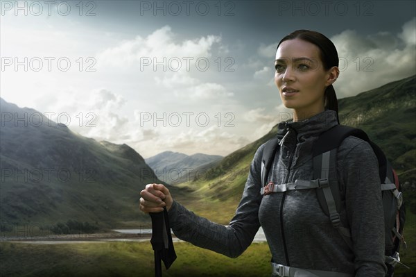 Caucasian woman hiking in green valley