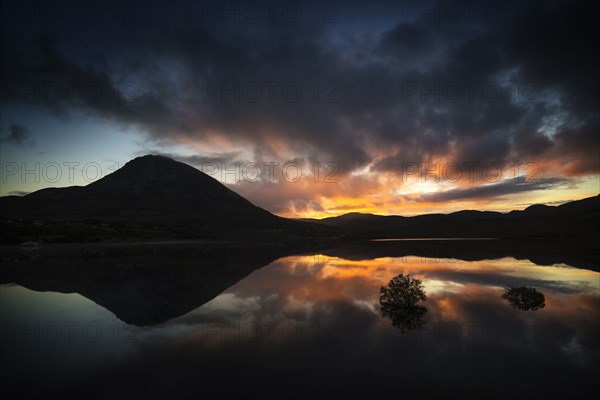 Reflection of sunset and mountain in water