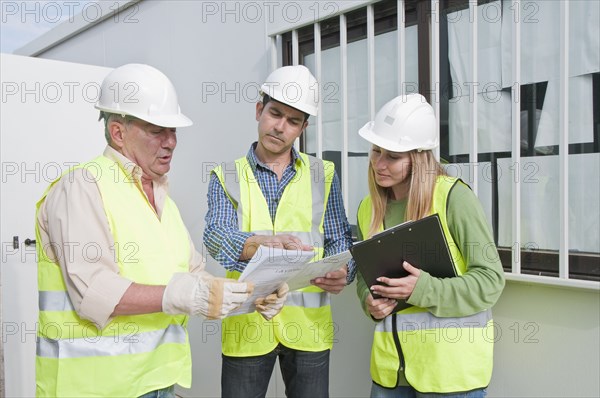 Hispanic construction workers reviewing paperwork