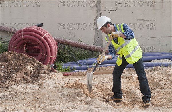 Hispanic construction worker digging