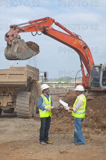 Hispanic construction workers talking on construction site