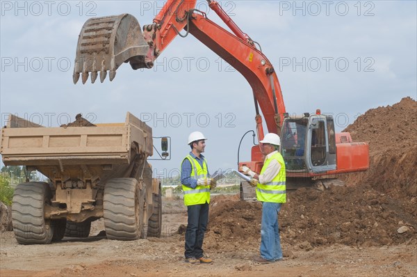 Hispanic construction workers talking on construction site