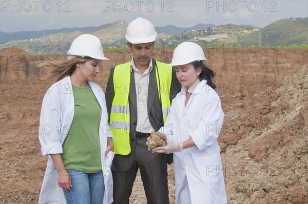 Workers analyzing rock specimen