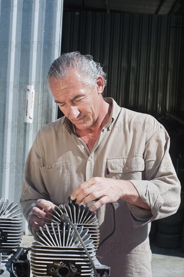 Hispanic mechanic working on engine