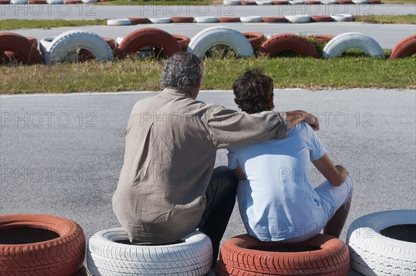 Hispanic grandfather and grandson on go-cart track