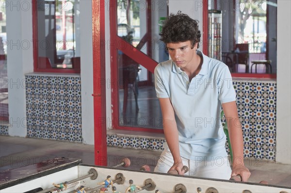 Hispanic teenager playing foosball