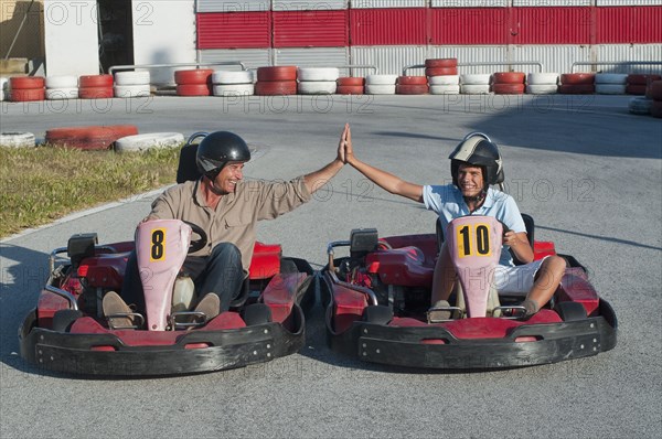 Hispanic grandfather and grandson on go-cart track