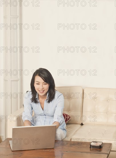 Korean woman using laptop in living room