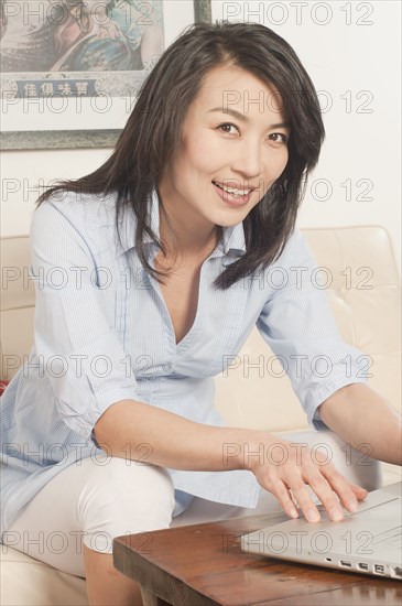 Korean woman using laptop in living room