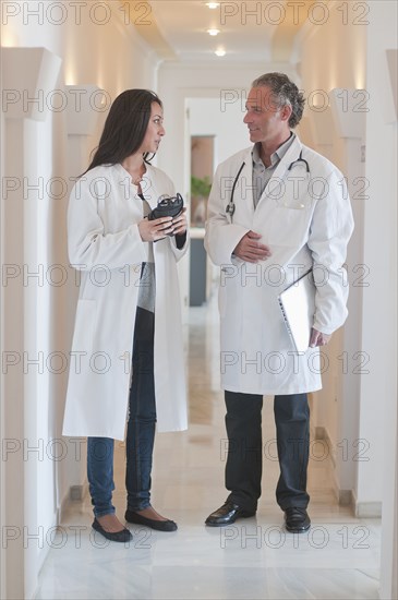 Hispanic doctors standing together in hospital corridor