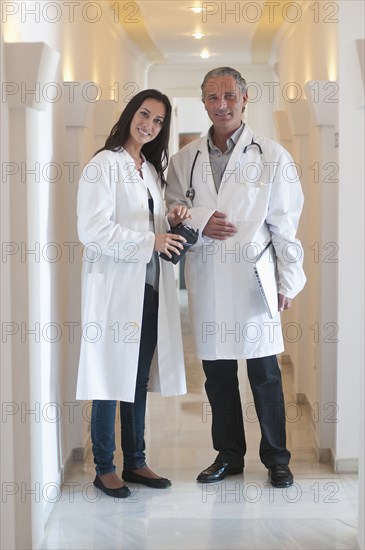 Hispanic doctors standing together in hospital corridor