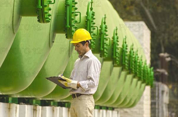 Hispanic worker checking tanks