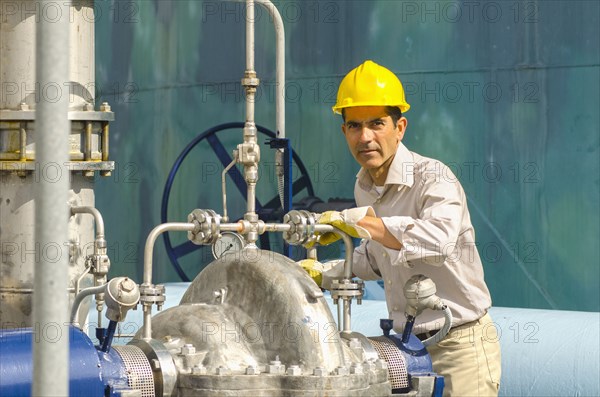 Hispanic worker checking valves