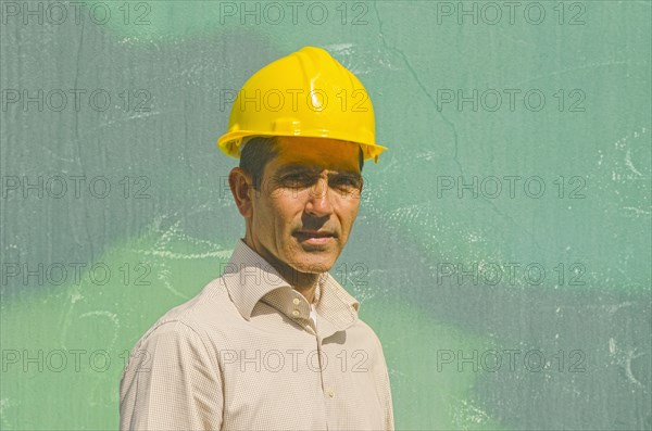 Hispanic worker wearing hard hat outdoors