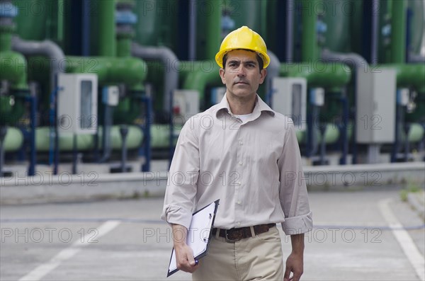 Hispanic worker wearing hard hat outdoors