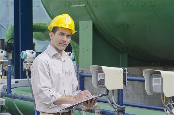 Hispanic worker checking machinery