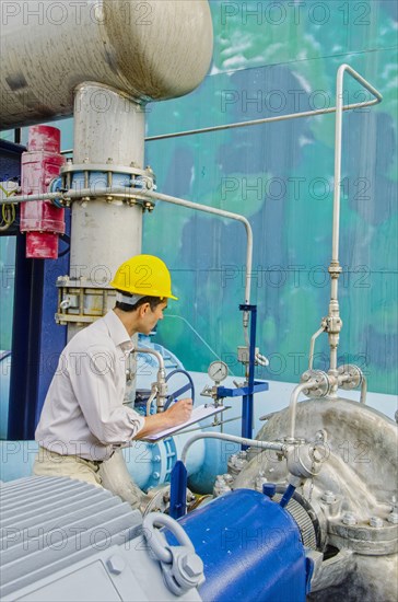 Hispanic worker checking machinery