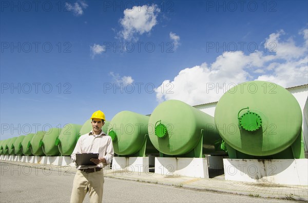 Hispanic worker checking tanks