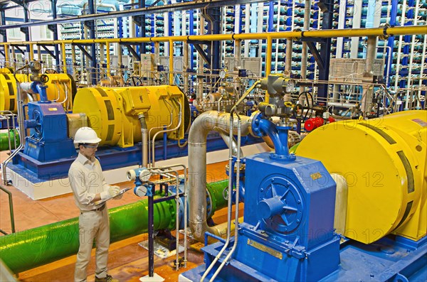 Hispanic worker checking machinery