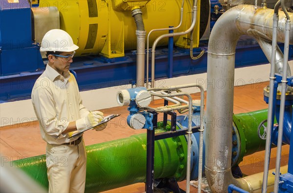 Hispanic worker checking machinery