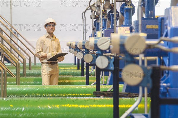 Hispanic worker checking machinery