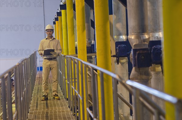 Hispanic worker checking machinery