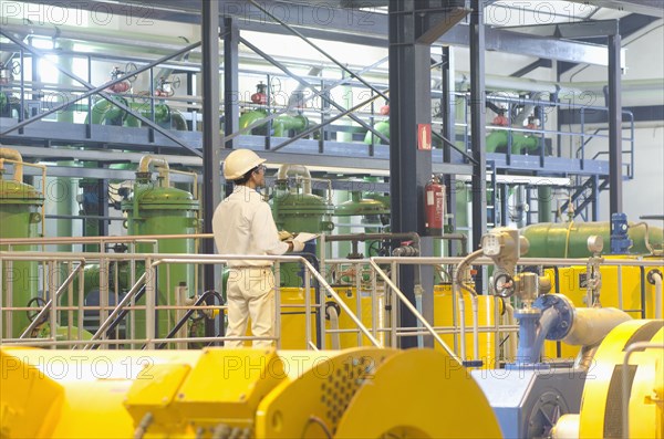 Hispanic worker checking machinery