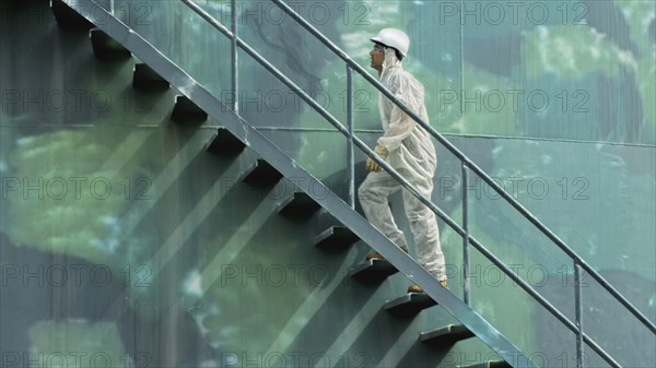 Hispanic worker climbing water tower