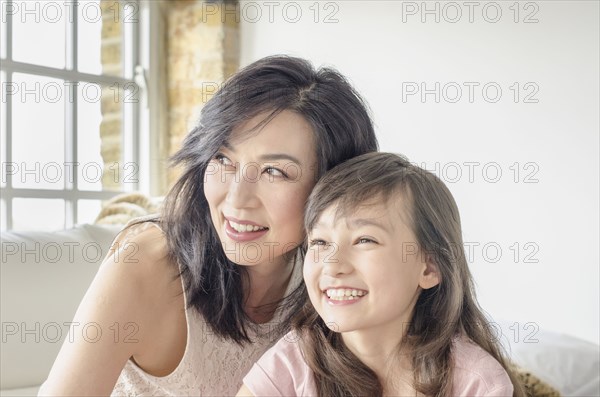 Mother and daughter smiling on sofa