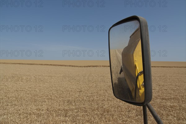 rear view mirror of combine harvester in field