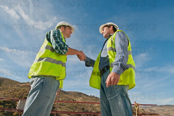 Two construction engineers shaking hands