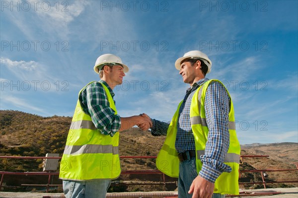 Two construction engineers shaking hands