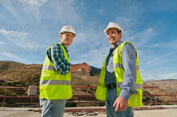 Two construction engineers shaking hands