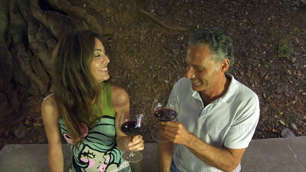 Couple drinking red wine in outdoors setting