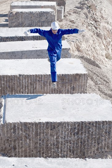 worker jumping between blocks of marble